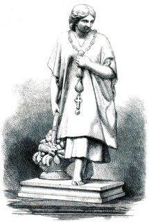 Statue of a female pilgrim from Guatemala. The figure is wearing a wide tunic that is reminiscent