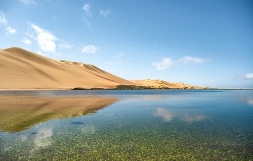 Sand dunes are reflected in Sandwich Harbour Lagoon, Impressive Desert Landscape, Namib Naukluft