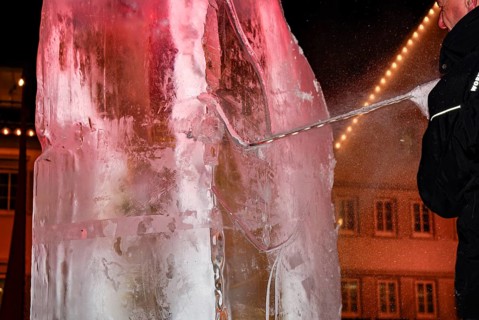 An ice sculpture is being created: ice carving street action as part of the long shopping night in