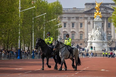 Mounted police officers riding along The Mall from Buckingham Palace, London, United Kingdom