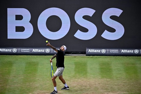 Nick Kyrgios (AUS) serving, with a Boss logo on the backboard in the background, BOSS Open 2026,