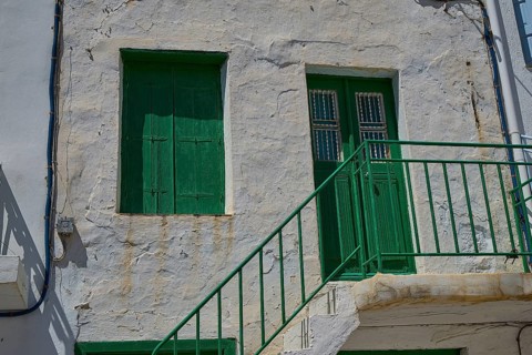 Old building with green door and shutters, rustic façade, Plaka, main town on Milos, Milos island,