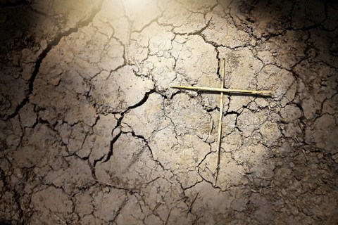 Dry soil with cracks and crosses, symbolic photo of damage caused by climate change, drought and