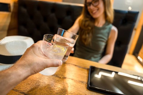 People toasting with refreshing cocktails at a table in a bar or restaurant, celebrating moments of