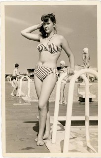 Bathing, swimwear, leisure, summer, outdoor pool, woman in striped bikini leaning on the railing of