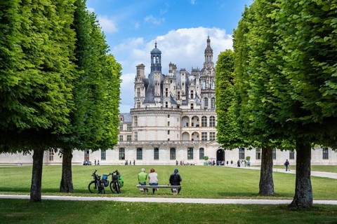 Tourists in the freely accessible park look at the monumental Renaissance Château de Chambord
