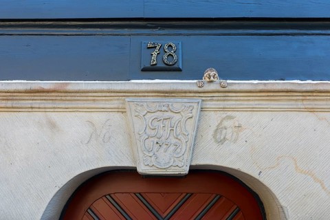 Coat of arms with initials and the year 1777 made of sandstone on a door frame of a half-timbered