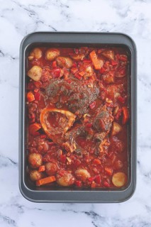 Ossobuco stew with vegetables, knuckle on the bone with new potatoes, in tomato sauce, homemade,