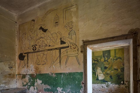 Sketchy wall drawing in an abandoned room, showing people at a table with typewriter, Lost Place,