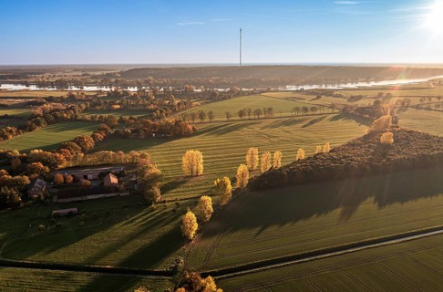 Aerial view of farmland and river Elbe near Lenzen, view to Höhbeck radio mast, sunset, Germany