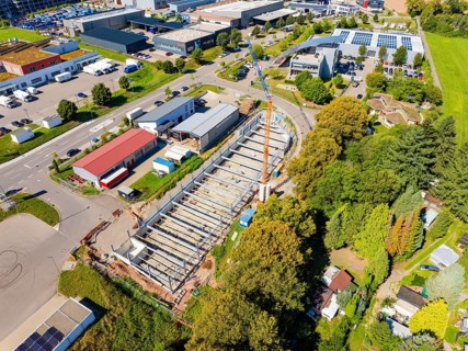 Aerial view of a large construction site with extensive vegetation and several buildings, Parkhaus