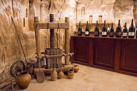 Ancient wine presses with surrounding bottles in a rustic cellar, sales room, Milestii Mici Winery,