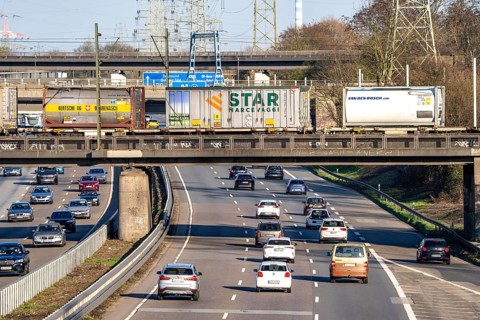 Freight train crosses the A42 motorway at Oberhausen-Zentrum on a railway bridge, the railway line