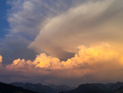 Evening sky at sunset with high strip-shaped cloud formations oriented in the form of arrows such