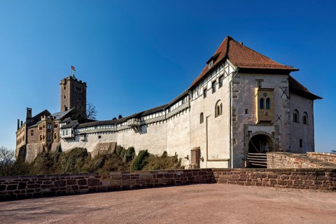 Castle with half-timbered buildings and red tiled roof against a clear sky, The Wartburg near