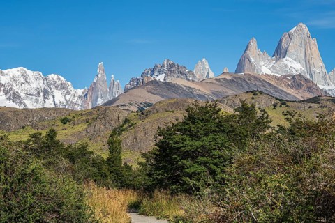Hiking trail at village El Chalten, mountain range of Cerro Torre and Cerro Fitz Roy in the back,