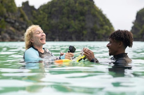 Tourist and guide enjoy snorkeling in the crystal-clear waters of Raja Ampat, West Papua,