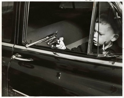 Child, game, pistol, car, A boy holds a toy gun out of a moving car, symbolic of curiosity and