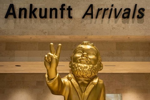 A giant golden garden gnome greets travelers and visitors in the arrivals area of the new Terminal