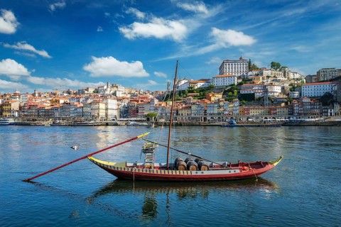 View of Porto city and Douro river with traditional boat with port wine barrels from famous tourist