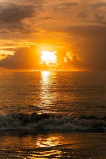 Breathtaking sunset over the ocean in Bali, Indonesia. Golden hues reflect on the sea, creating a