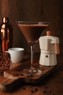 Espresso martini cocktail, alcoholic drink, shaker and geyser coffee maker, on a wooden background
