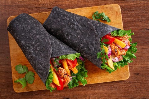 Shawarma in black lavash, on a wooden background, chicken shawarma, no people