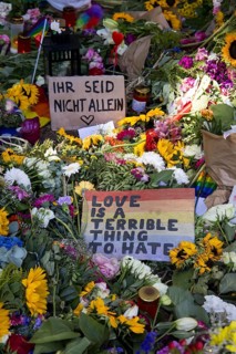 Signs reading ‘You are not alone' and ‘Love is a terrible thing to hate' at an impromptu memorial