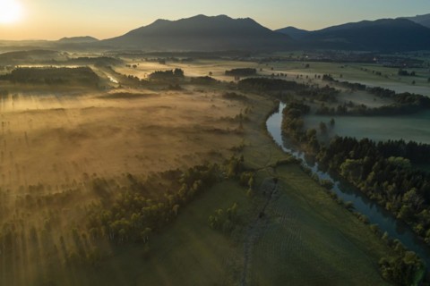Aerial view of a moor landscape with river in front of mountains, morning light, backlight, view of