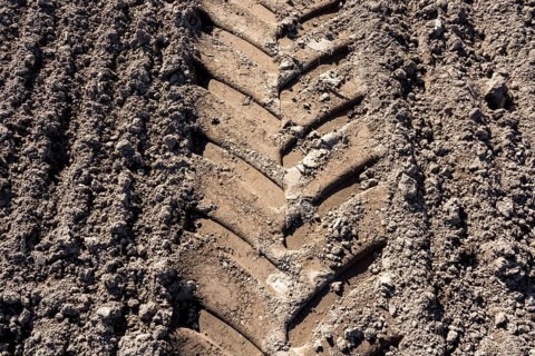 Tractor tracks, agricultural trails at a cultivated field in springtime, farmland near Wesertal,