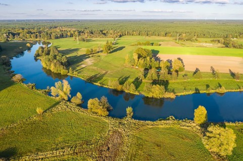 River Aller winding throug cultural landscape west of city Celle, mix of farmland, meadows and