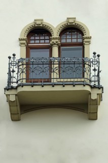 Balcony with metal railing and two windows decorated with an Art Nouveau villa, house façade,