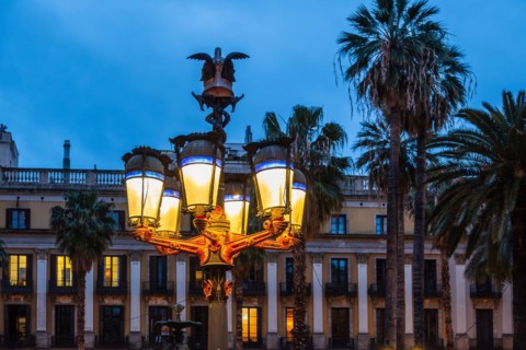 Nightlife at Plaça Reial, lanterns by Gaudi in the historic centre of Barcelona, Spain