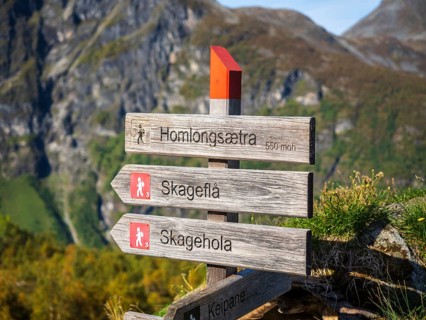 Signpost at Alpe Homlongsætra above the Geirangerfjord, traditional summer farm, Geirangerfjord,