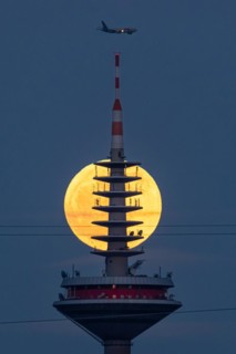 The full moon passes behind the top of the Europaturm in Frankfurt am Main, Frankfurt am Main,