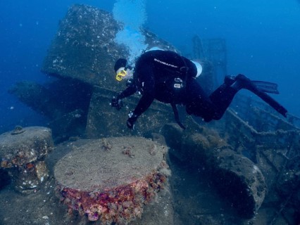 Diver examines an overgrown underwater wreck, dive site wreck of the Vis, Pula, Croatia,