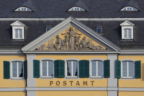 Baroque post office with tympanum and relief built in 1753, green shutters, inscription, main post