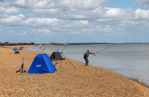 People fishing on the beach between Bawdsey and Shingle Street, Hollesley Bay, Suffolk, England, UK