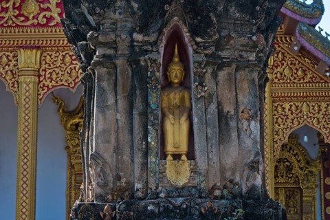 Small golden Buddha in front of Wat Xieng Mouane, Luang Prabang, Laos