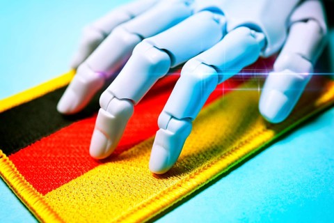 Robot hand on German flag, promotion of AI technologies, photo montage +++ editorial use only