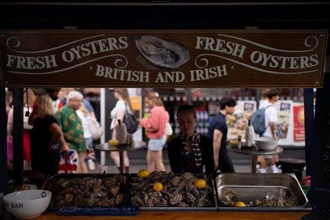 Offering fresh oysters at a market stand with people strolling behind, tourists, market, Portobello