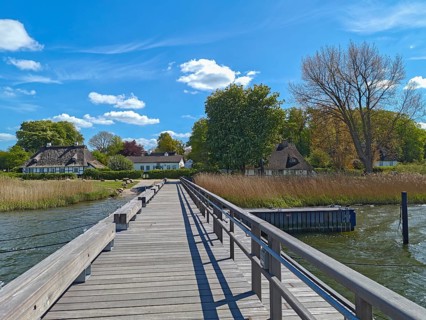 Jetty with thatched houses, half-timbered house, blue sky, sunshine, cumulus clouds, shore with