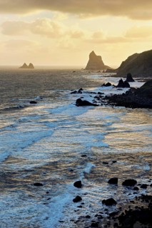 Beach of Playa de Benijo at high tide with the rock Roques de Anaga in the light of the rising sun,