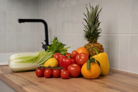 A vibrant assortment of fresh fruits and vegetables, including pineapple, tomatoes, and bell