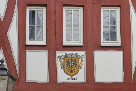 Red-brown half-timbered house Cafe Zeitgeist with city coat of arms and three windows, Boppard,