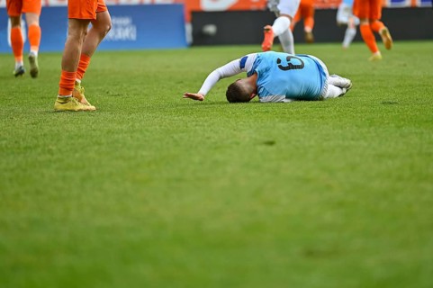 The injured footballer lies on the pitch in Lubin, Poland