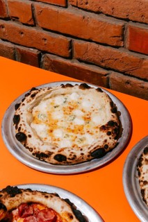 A freshly baked Four Cheese Pizza featuring parmesan, mozzarella, and dorblu cheese on a crisp