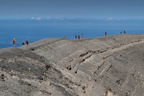 Visitors walk along the crater rim, Vulcano, Aeolian or Aeolian Islands, Sicily, Southern Italy,