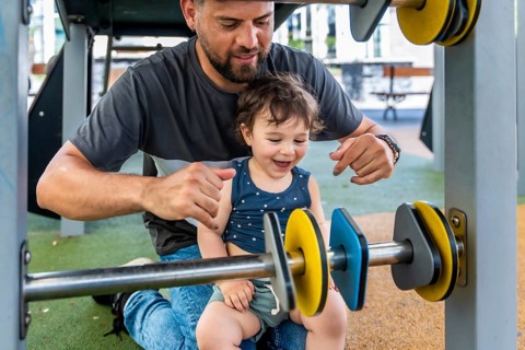 Father and young son enjoying a carefree moment, laughing and interacting with a colorful abacus