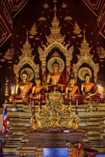 Seated gilded Buddha figures in a public prayer room of a Buddhist temple complex, Old City Center,